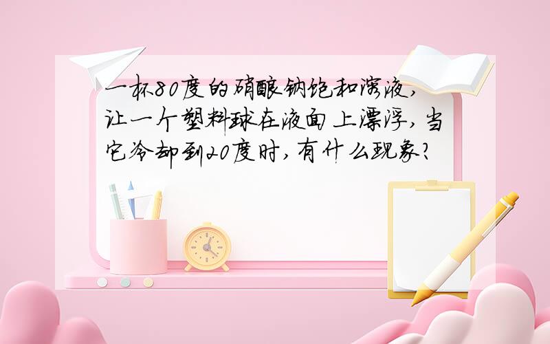 一杯80度的硝酸钠饱和溶液,让一个塑料球在液面上漂浮,当它冷却到20度时,有什么现象?